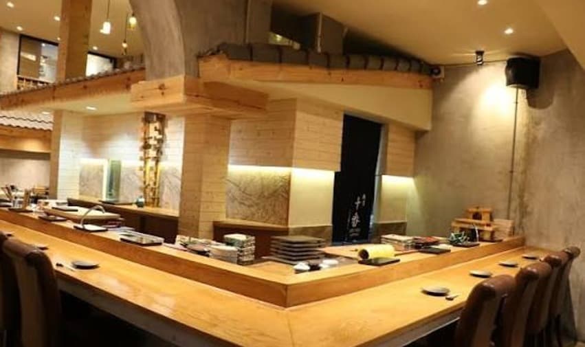 職人の手元を見ながら贅沢なひと時を過ごせる「寿司十番 本店 SUSHI JUBAN Asok Branch」の木製Ｌ字型カウンター席