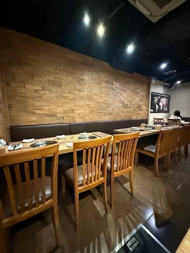 木目調のテーブルと卓上ロースターが並ぶ店内｜Gyu-Kaku Japanese BBQ