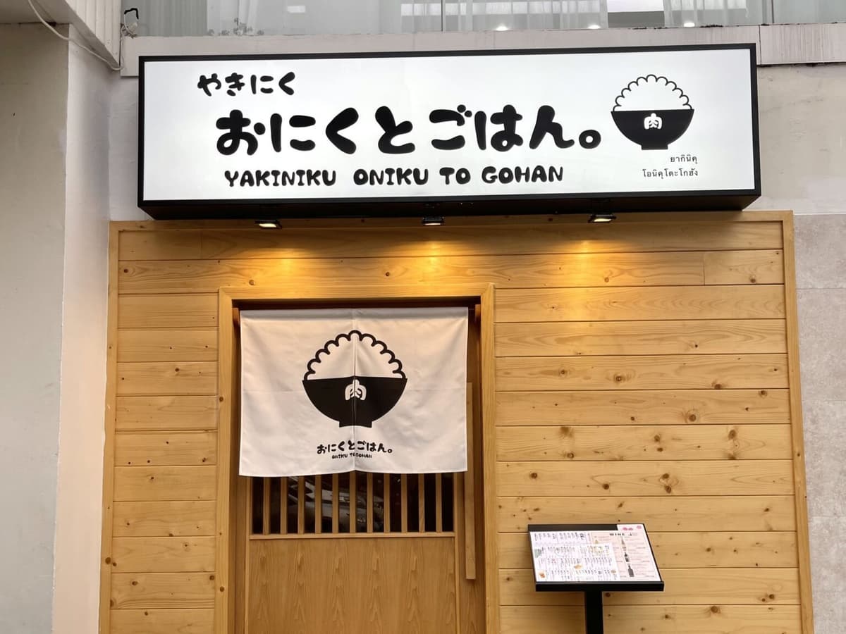 「焼肉 おにくとごはん。」の看板と木目調の店舗入口